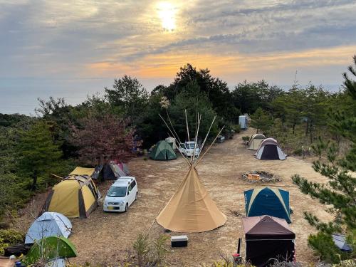 四万十市雅玛米苏度假屋的一群帐篷和汽车在田野里