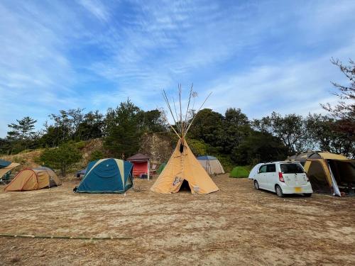 四万十市雅玛米苏度假屋的一群帐篷和停在田野里的一辆汽车