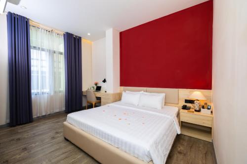 胡志明市Khách sạn Phước Lộc Thọ 2 - 福禄寿的一间卧室设有一张红色墙壁的大床