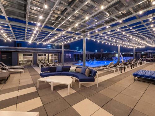 艾迪生Elite Retreat in Addison Circle的一个带蓝色沙发和椅子的泳池间