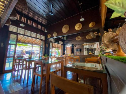 安帕瓦Thanicha Resort Amphawa的一间在房间内配有桌椅的餐厅