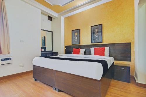 古尔冈Super Capital O Tipsyy 006 Near Aravali Biodiversity Park的一间卧室配有一张带红色枕头的大床