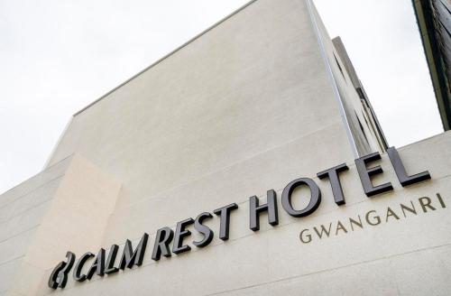 釜山Gwanganli Calm Rest Hotel的建筑物一侧的标志