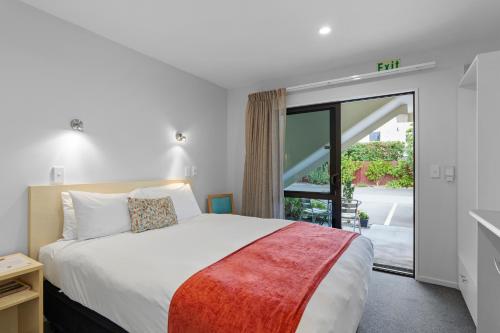 基督城Bella Vista Motel & Apartments Christchurch的一间卧室设有一张床和一个大窗户