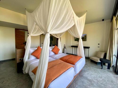 珀尼达岛MAUA Nusa Penida Bali的一间卧室配有两张床和一张天蓬床。