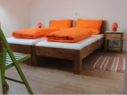巴门塔尔Apartment "Max & Moritz"的客房内的两张床和橙色枕头