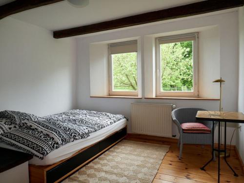 利嫩Holperdorp Modern retreat的一间卧室配有一张床、一张书桌和两个窗户。