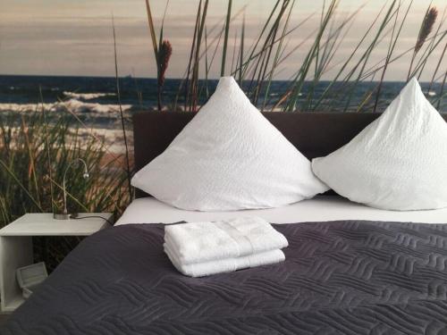 不来梅港Holiday apartment WeserWeitblick的床上配有毛巾和枕头