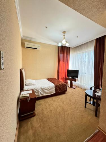 塔拉兹Luxurious的酒店客房,配有床和电视