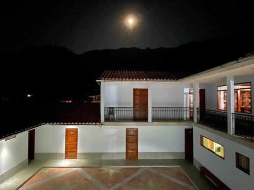 Chavín de HuantarHotel Restaurante Minas Cocha的夜晚与月亮相阳台的房子