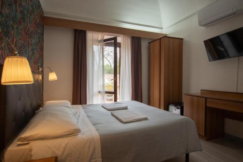 比萨弗朗切斯科酒店的酒店客房设有床和窗户。