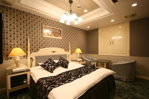 奈良D-CUBE奈良店的一间卧室配有一张大床,提供黑白枕头