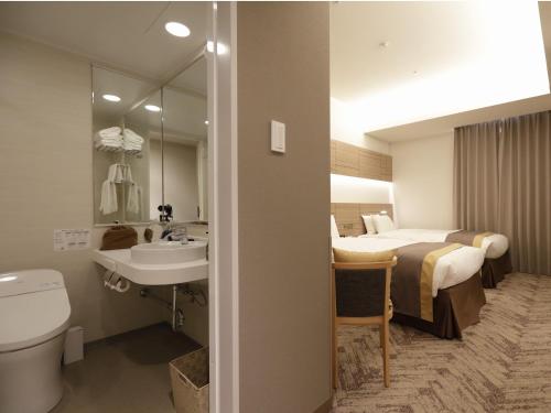东京日本青年馆酒店的浴室设有床、卫生间和水槽。