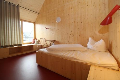 TeuschnitzSchwarzes Kreuz的卧室配有木墙内的一张床