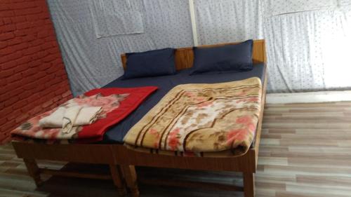 穆索里Kandi Orchard Resort的一张带蓝色枕头的床和一张毯子