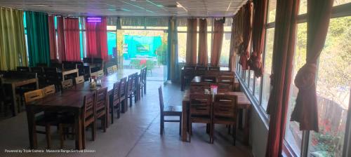 穆索里Kandi Orchard Resort的用餐室设有桌椅和窗户。