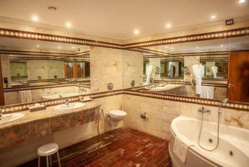 突尼斯突尼斯大酒店的一间带两个盥洗盆、浴缸和卫生间的浴室