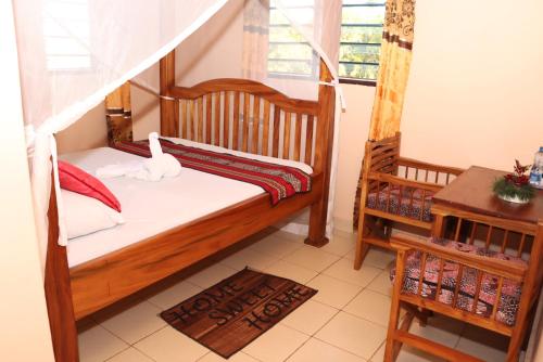 乌昆达Pebbles guesthouse in Diani beach road的一间小卧室,配有床和窗户