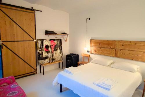 葛伦坦马勒A Casa Da Angelo - Country House PrivatePool & AirCO的卧室配有白色的床和木门