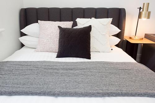 悉尼Comfortable Renovated Studio Close To City的一张带白色枕头和黑色床头板的床
