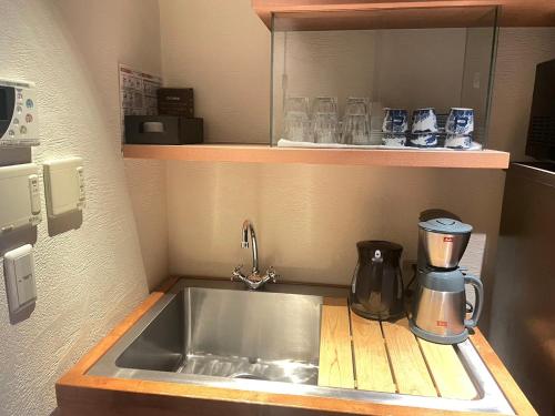 Giommachi京都　水凪庵　Kyoto Mizunagian的厨房柜台配有水槽和咖啡壶
