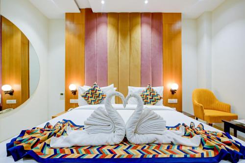 阿姆利则Classio Royale By IO Hotels的一间卧室配有一张带两只天鹅的毛巾床