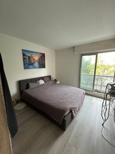 圣莫里斯Appartement spacieux , proche JO Paris的一间卧室设有一张床和一个大窗户