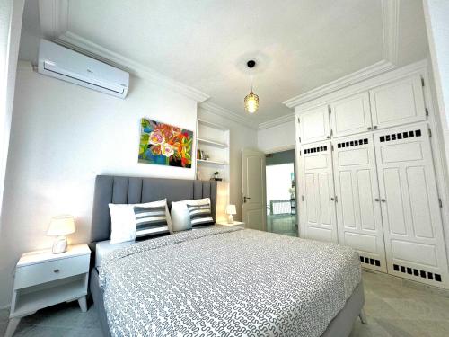 西迪·布·赛义德Cosy S3 Apartment in Sidi Bou Said Village的白色卧室配有一张床和一个白色衣柜