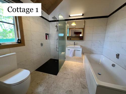 奥林达奥林达乡村小屋酒店的带浴缸、卫生间和盥洗盆的浴室