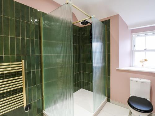 阿什伯恩The Loft at The Old Dog Thorpe的浴室设有绿色瓷砖和淋浴。