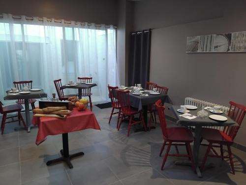 容扎克莱斯瑟尔姆斯酒店的用餐室配有黑色桌子和红色椅子