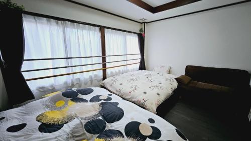 京都Kyoto - Apartment - Vacation STAY 98413v的一间卧室配有一张床、一张沙发和一个窗口