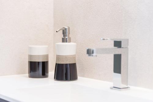波尔图GuestReady - Modern luxe getaway in Vitória的浴室水槽和肥皂机