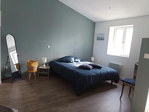 格吕桑Jolie Maison au centre du village的一间卧室配有一张蓝色墙壁的床和一扇窗户