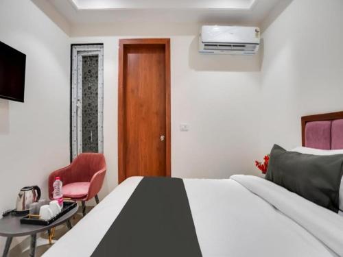 新德里HOTEL IVORY INN NEW DELHI At IGI AIRPORT的卧室配有1张床、1张桌子和1把椅子