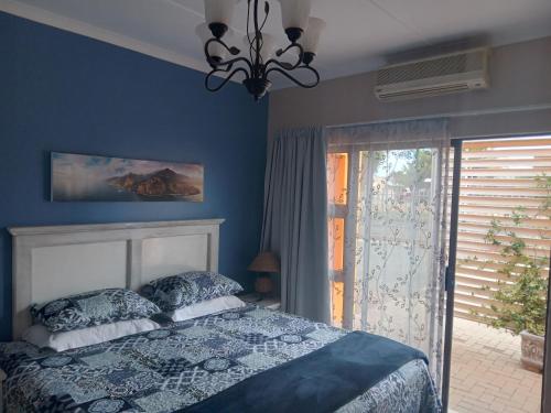 布隆方丹SONHOS dreams Self catering apartment Unit 1的蓝色的卧室设有床和窗户