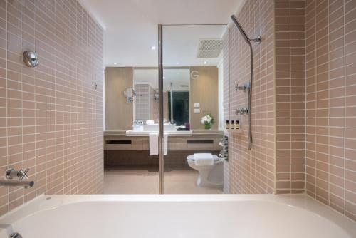北芭堤雅Pullman Pattaya Hotel G的带浴缸、卫生间和盥洗盆的浴室