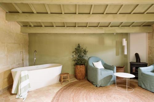 阿莱奥尔Amagatay Menorca的带浴缸、椅子和桌子的浴室