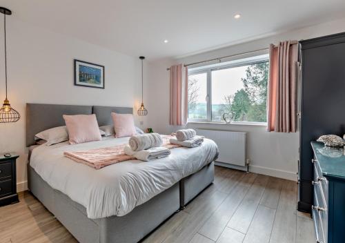 ChittlehamptonGreenacres的卧室配有一张大床和粉红色枕头。