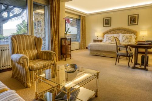 塞奥-德乌赫尔HOTEL & SPA El Castell de Ciutat的酒店客房带一张床、一张桌子和椅子