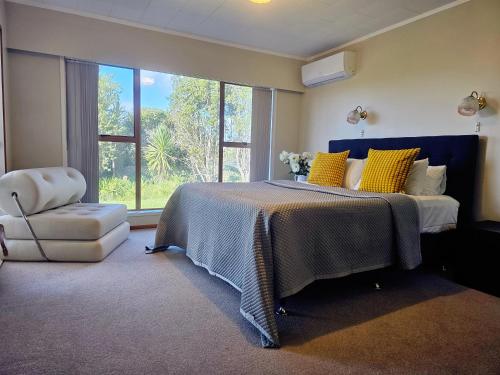 奥克兰The waterfront 361-Family retreat with Netflix Skysport Air conditioner in each bedroom的一间卧室配有一张带黄色枕头和椅子的床