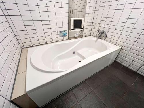 京都もしもしピエロ NEO 京都店的白色瓷砖浴室内的白色浴缸