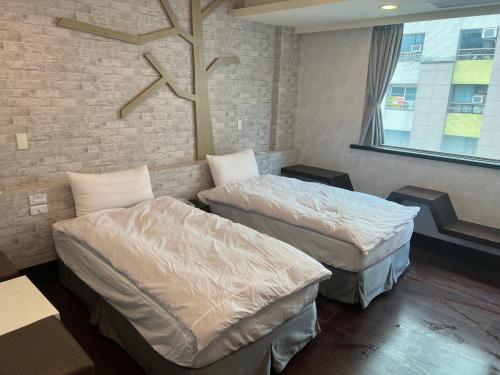 礁溪凯丽温泉饭店的砖墙客房的两张床
