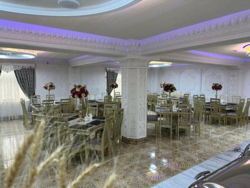 撒马尔罕Zilol Baxt Hotel的一间配备有桌椅和紫色照明的用餐室
