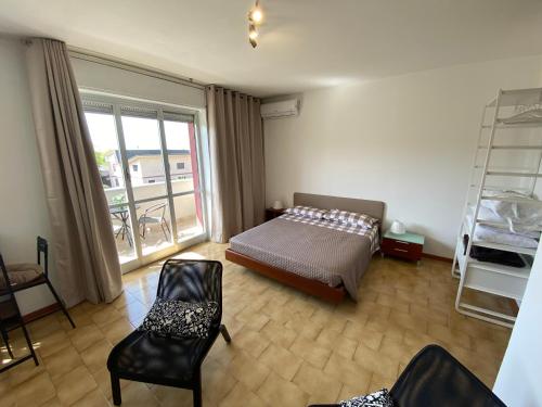 诺瓦拉Appartamento 44的一间卧室配有一张床铺和椅子,设有一个阳台