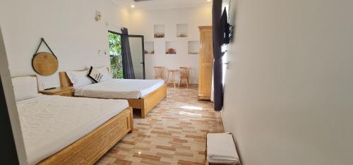 Ninh HaiSunrise Dốc Lết的一间设有两张床和一张桌子及椅子的房间