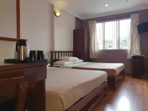 伯恩仓Hotel Sentosa的酒店客房设有两张床和窗户。