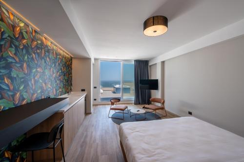 里乔内Hotel Sporting Riccione的酒店客房设有一张床,享有海景。