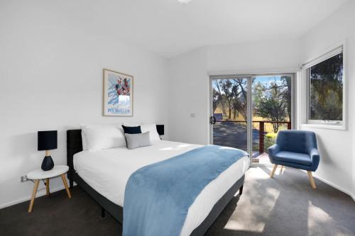 Goughs BayMountain Bay Retreat near Goughs Bay Sleeps 10的一间卧室配有一张大床和一张蓝色椅子