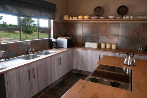波罗瓜尼Casa de la Presa 3的厨房配有木制橱柜、水槽和桌子